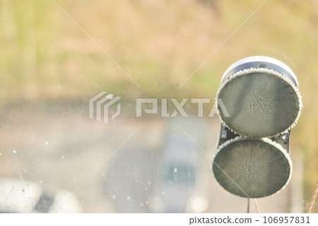 A window cleaner robot washes glass against the backdrop of multi-storey buildings. 106957831