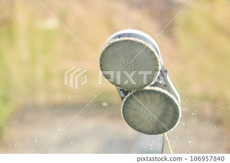 A window cleaner robot washes glass against the backdrop of multi-storey buildings. 106957840