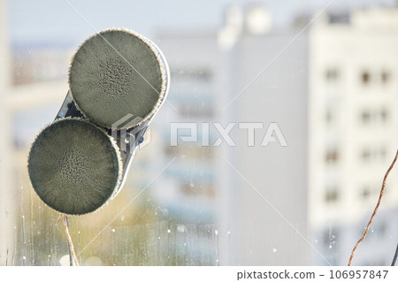 A window cleaner robot washes glass against the backdrop of multi-storey buildings. 106957847