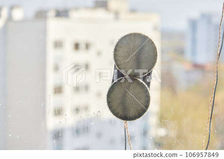 A window cleaner robot washes glass against the backdrop of multi-storey buildings. 106957849