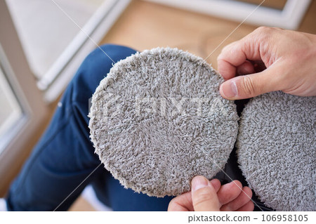 A window cleaner robot washes glass against the backdrop of multi-storey buildings. 106958105