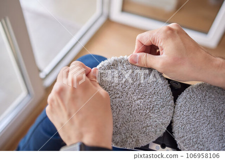 A window cleaner robot washes glass against the backdrop of multi-storey buildings. 106958106