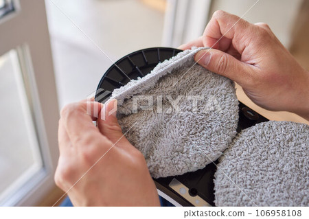 A window cleaner robot washes glass against the backdrop of multi-storey buildings. 106958108