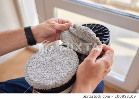 A window cleaner robot washes glass against the backdrop of multi-storey buildings. 106958109