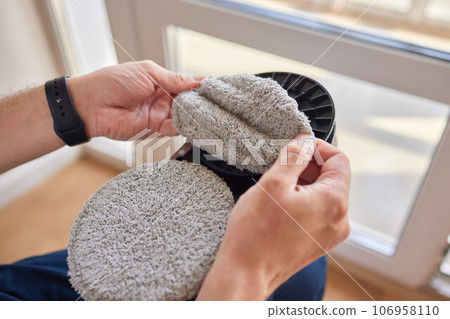 A window cleaner robot washes glass against the backdrop of multi-storey buildings. 106958110