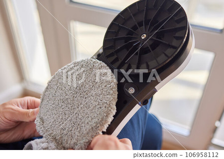 A window cleaner robot washes glass against the backdrop of multi-storey buildings. 106958112