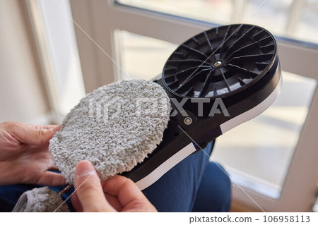 A window cleaner robot washes glass against the backdrop of multi-storey buildings. 106958113