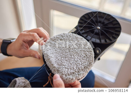 A window cleaner robot washes glass against the backdrop of multi-storey buildings. 106958114
