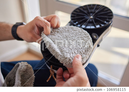A window cleaner robot washes glass against the backdrop of multi-storey buildings. 106958115
