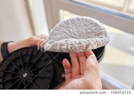 A window cleaner robot washes glass against the backdrop of multi-storey buildings. 106958119