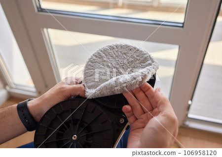 A window cleaner robot washes glass against the backdrop of multi-storey buildings. 106958120