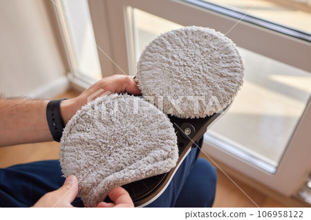 A window cleaner robot washes glass against the backdrop of multi-storey buildings. 106958122