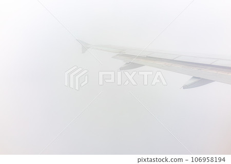View from the airplane window at a beautiful cloudy sky and the airplane wing 106958194