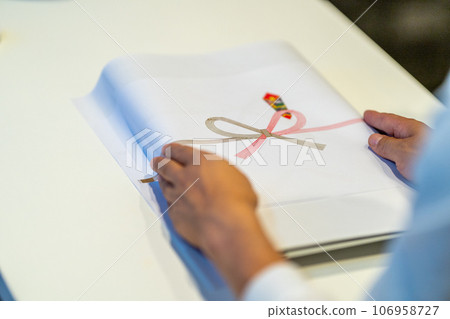 Both hands attaching paper to items Both hands attaching paper to items 106958727