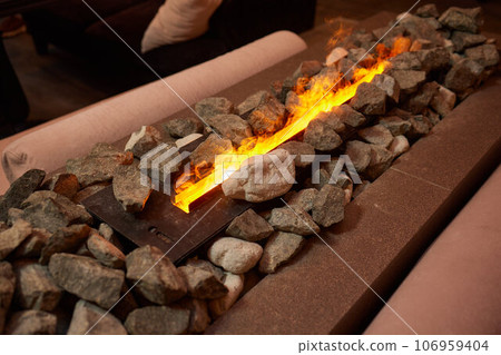 Electric log fireplace. Restaurant showcase decorated with artificial heater. Exterior design. Electric log fireplace. Restaurant showcase decorated with artificial heater. Exterior design. 106959404