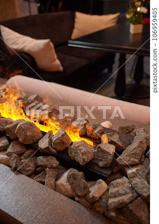 Electric log fireplace. Restaurant showcase decorated with artificial heater. Exterior design. Electric log fireplace. Restaurant showcase decorated with artificial heater. Exterior design. 106959405