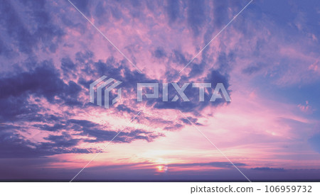 Purple cloudy sky at sunset. Sky texture. Abstract nature background Purple cloudy sky at sunset. Sky texture. Abstract nature background 106959732