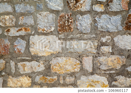 Sturdy yellow and beige cut stone wall made in Datca, Turkey, seamless lined up 106960117