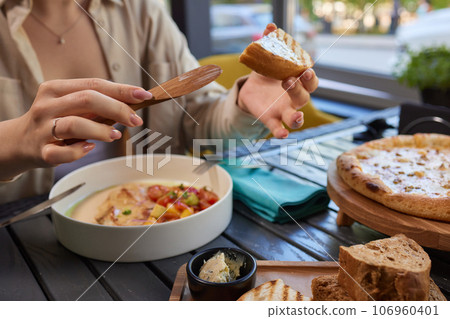 Healthy breakfast. happy young woman preparing tasty snacks at the kitchen table in the morning light. 106960401