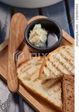 A piece of rye bread with a bunch of thyme on a wooden old stand. Farmer's early Breakfast. A piece of rye bread with a bunch of thyme on a wooden old stand. Farmer's early Breakfast. 106960503