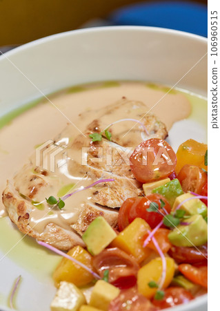 Young woman hand eating donburi with chicken and rice using knife and fork fom bowl. Young woman hand eating donburi with chicken and rice using knife and fork fom bowl. 106960515