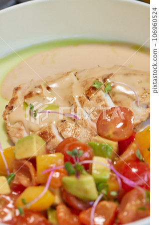 Young woman hand eating donburi with chicken and rice using knife and fork fom bowl. Young woman hand eating donburi with chicken and rice using knife and fork fom bowl. 106960524