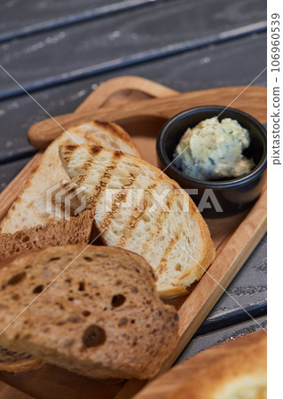 A piece of rye bread with a bunch of thyme on a wooden old stand. Farmer's early Breakfast. A piece of rye bread with a bunch of thyme on a wooden old stand. Farmer's early Breakfast. 106960539