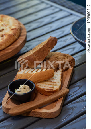 A piece of rye bread with a bunch of thyme on a wooden old stand. Farmer's early Breakfast. A piece of rye bread with a bunch of thyme on a wooden old stand. Farmer's early Breakfast. 106960542