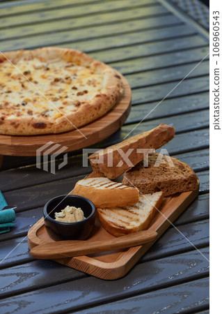 A piece of rye bread with a bunch of thyme on a wooden old stand. Farmer's early Breakfast. A piece of rye bread with a bunch of thyme on a wooden old stand. Farmer's early Breakfast. 106960543