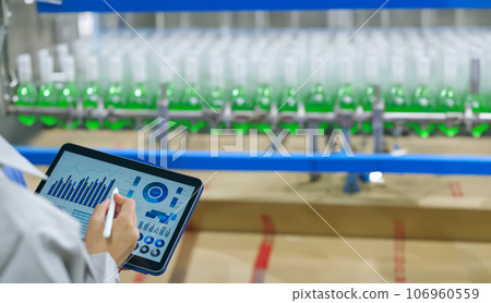 Engineer managing a beverage factory with a tablet Engineer managing a beverage factory with a tablet 106960559