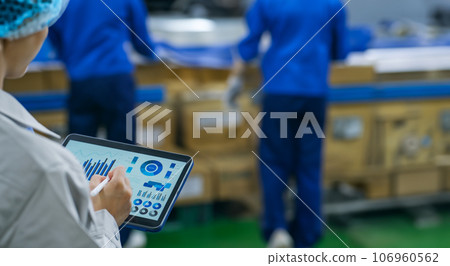 A worker using a tablet in a factory 106960562