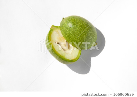 The green outer shells of the unripe walnuts are cut in half, green walnuts 106960659