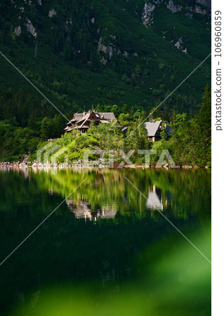 View on cabin in mountains with green forest. House for tourists in Tatra National Park near Morskie Oko or Eye Sea lake. Touristic place in Poland 106960859