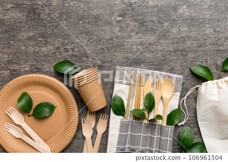 set of empty reusable disposable eco-friendly plates, cups, utensils on light white colored table background. top view. Biodegradable craft dishes. Recycling concept. Close-up 106961504