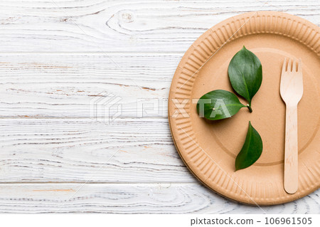 set of empty reusable disposable eco-friendly plates, cups, utensils on light white colored table background. top view. Biodegradable craft dishes. Recycling concept. Close-up 106961505