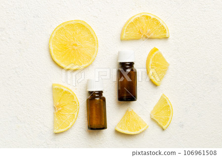Bottles with lemon fruit essential oil on wooden background. alternative medicine top view with copy space Bottles with lemon fruit essential oil on wooden background. alternative medicine top view with copy space 106961508