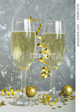 Champagne glasses and christmas decor on colored holiday background. Flat lay New Year decorations 106961550