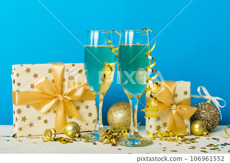 Champagne glasses and christmas decor on colored holiday background. Flat lay New Year decorations 106961552