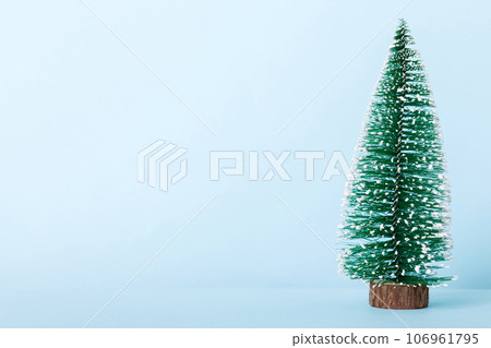One small Christmas tree on colored background. new year decoration with copy space 106961795