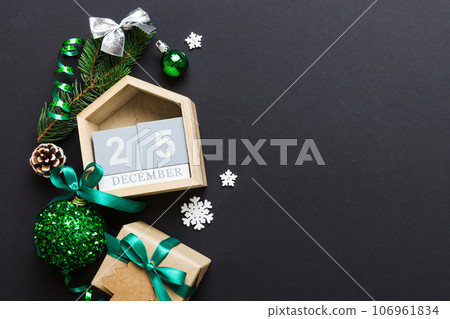Christmas calendar 25 december. Christmas gift, fir branches, pine cones. Flat lay, top view. New Year decorations on a colored background 106961834
