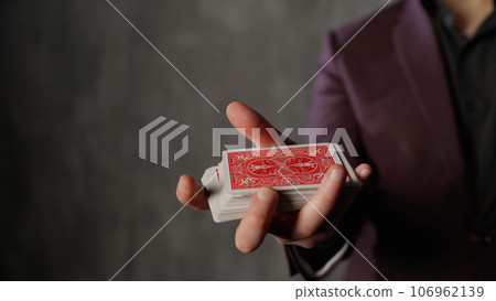 Card magician, croupier in a casino smoothly shows a deck of cards. Card trick game. Focus on a deck of playing cards close up. Card magician, croupier in a casino smoothly shows a deck of cards. Card trick game. Focus on a deck of playing cards close up. 106962139