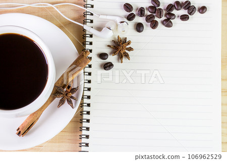 Coffee and open notebook on wooden table Coffee and open notebook on wooden table 106962529
