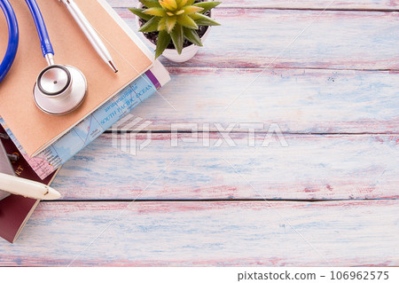 Flat lay photo with blank notebook, pen and blue stethoscope on wooden table background. 106962575