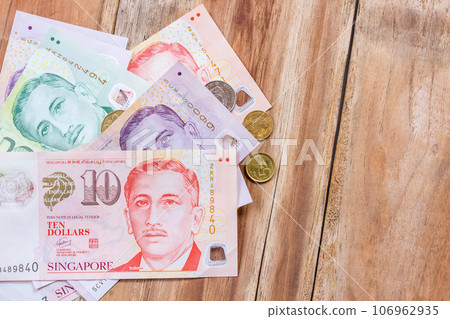 Singapore money on wooden table background Singapore money on wooden table background 106962935