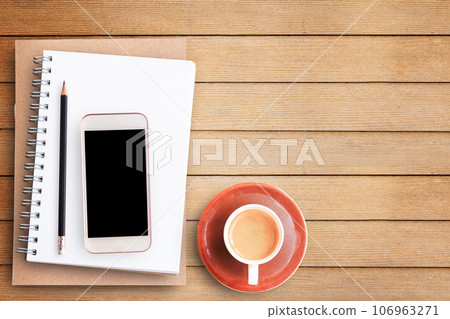 Empty blank paper notebook and smart phone on brown wooden table Empty blank paper notebook and smart phone on brown wooden table 106963271