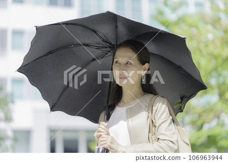 Portrait of a senior woman pointing at a parasol Portrait of a senior woman pointing at a parasol 106963944