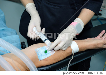 Injecting anesthesia through a catheter on the patient's arm. Injecting anesthesia through a catheter on the patient's arm. 106964102