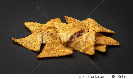 Corn chips, hot Mexican nachos isolated on black background Corn chips, hot Mexican nachos isolated on black background 106964593