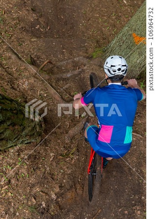 Man riding a mountain bike through a wooded area on summer day. Man riding a mountain bike through a wooded area on summer day. 106964732