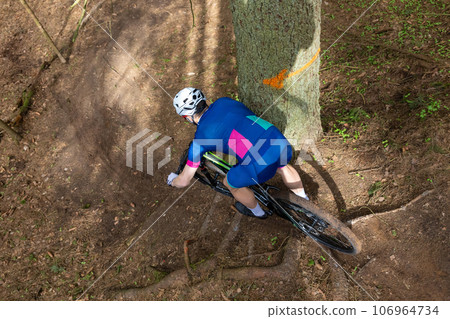 Man riding a mountain bike through a wooded area on summer day. Man riding a mountain bike through a wooded area on summer day. 106964734